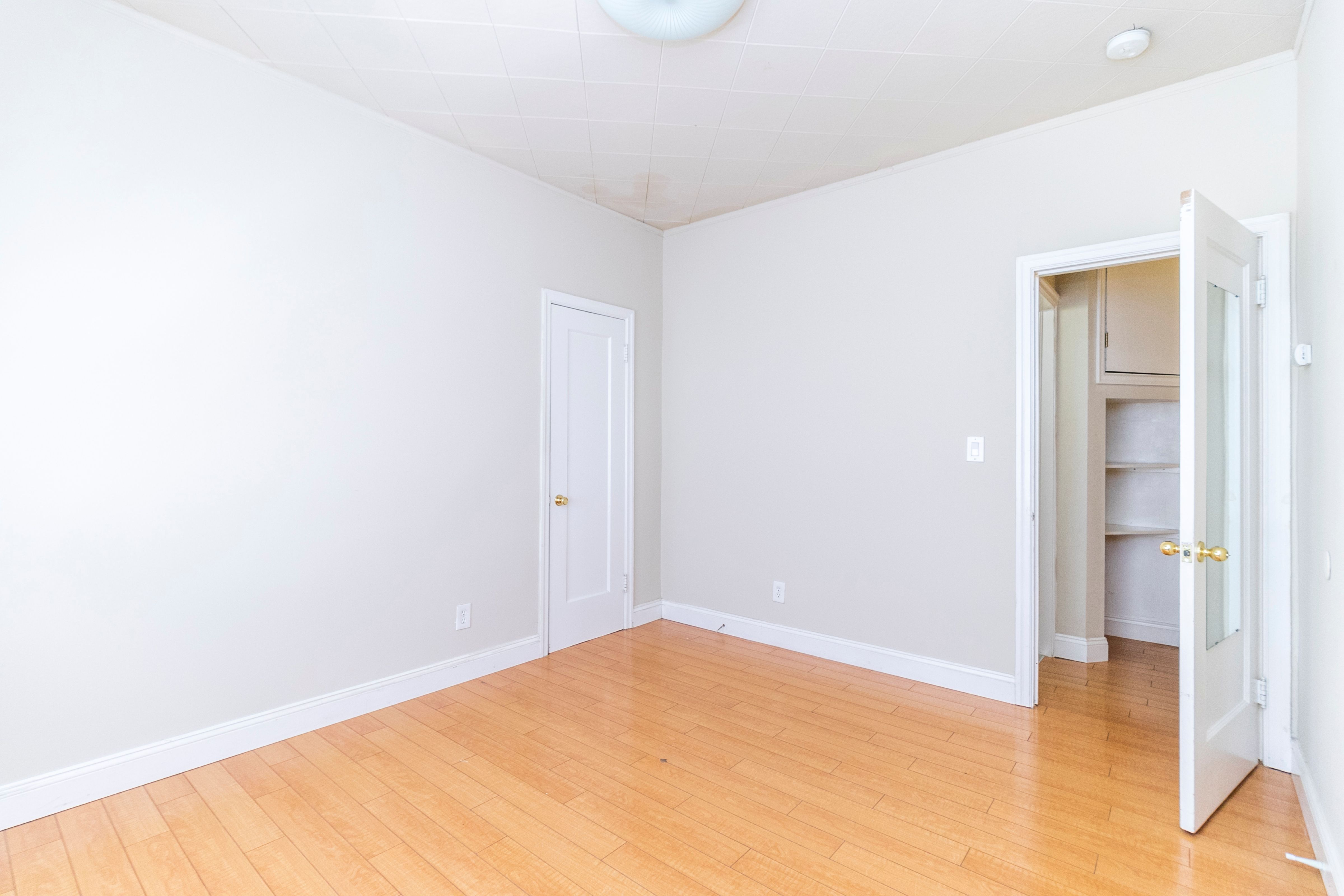 A room with a white door and a white wall.